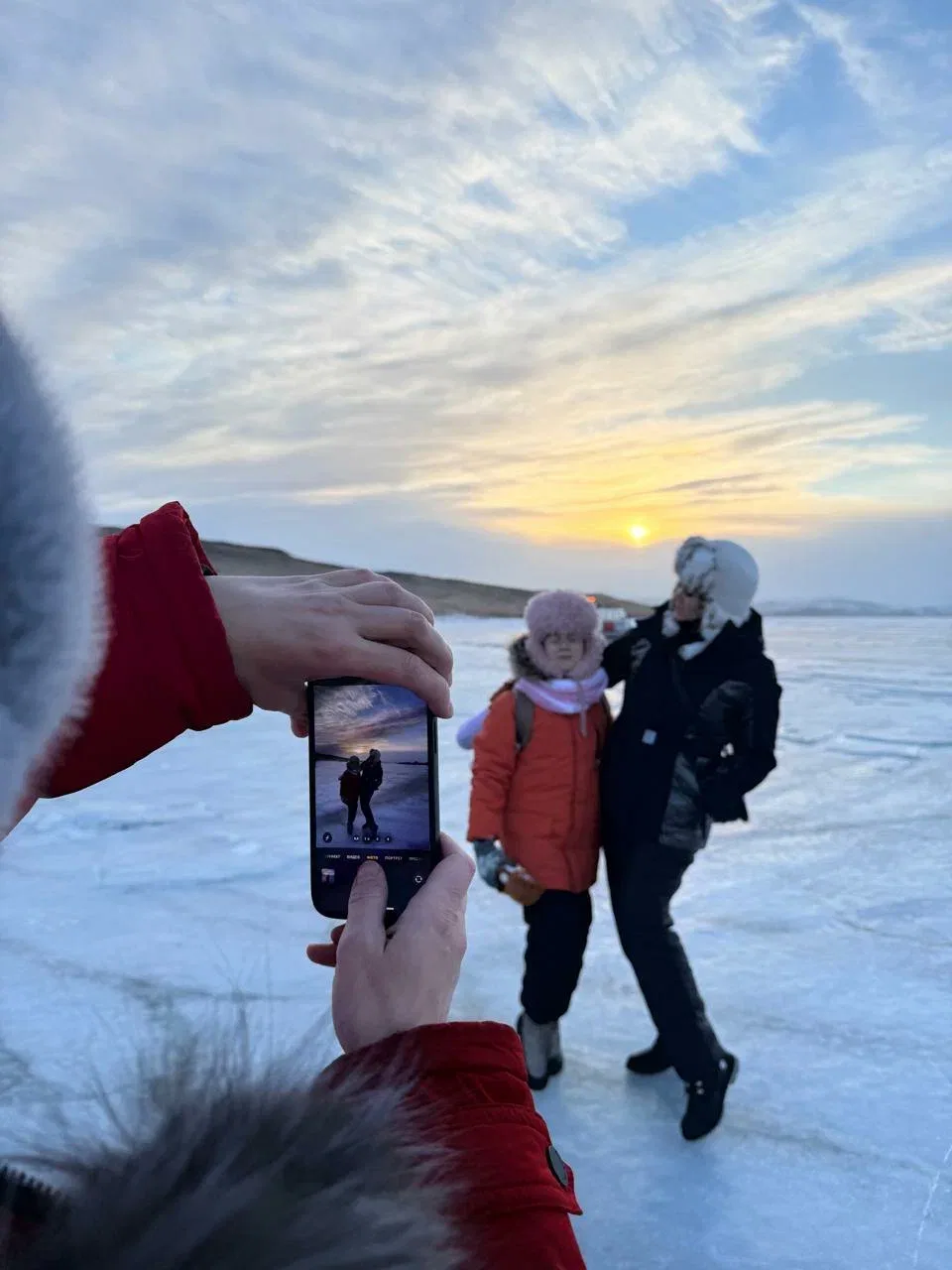 Люди фотографируются на льду Байкала